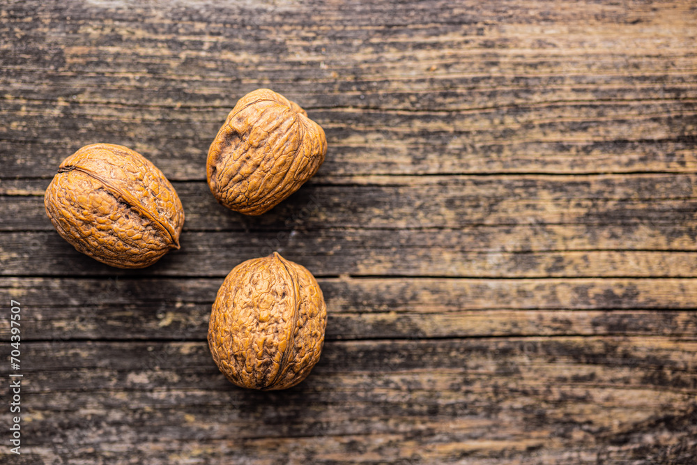 Three walnuts on wooden table. Top view. Three walnuts on wooden table. Top view.