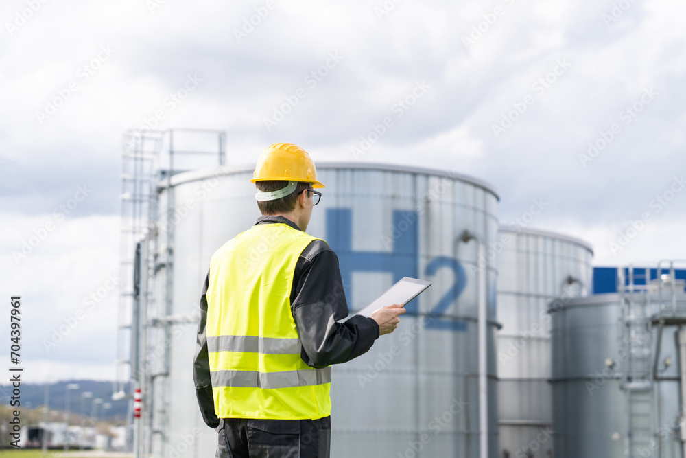 Engineer with tablet computer on a background of Hydrogen factory Engineer with tablet computer on a background of Hydrogen factory