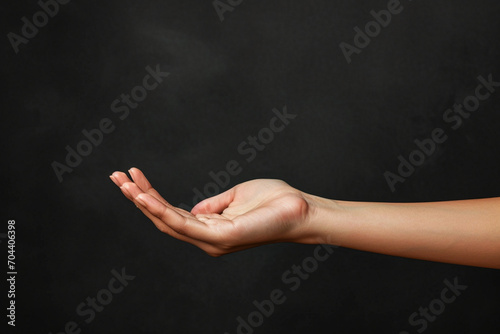 The image of an elegant woman's hand with an empty palm up portrays a sense of grace and openness. This gesture often symbolizes receptiveness, invitation, or readiness to receive something—a gift, an