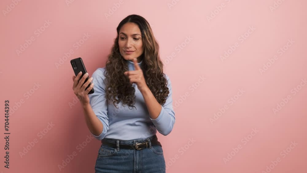 Woman using phone and pointing at the side Woman using phone and pointing at the side