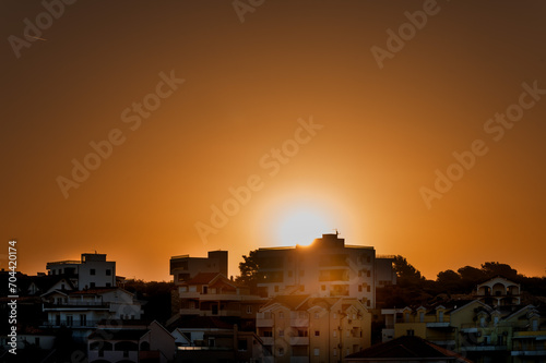 Wschód słońca nad Chorwackim miastem. Miasto w chorwacji. Wschód słońca nad budynkami. Wschód słońca nad dachami domów. Domy w Chorwacji © Daniel
