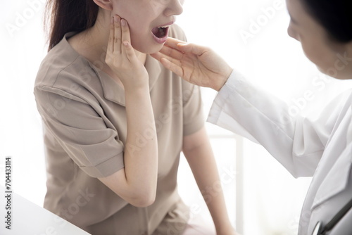 Doctor checking patient's toothache in office