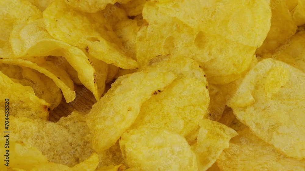 Potato chips rotating close up on a wooden board. Potato chips rotating close up on a wooden board.