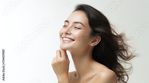 Asian woman with flawless skin smiling and touching her face