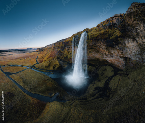 Aerial shot of Seljalandsfoss is located in the South Region on Iceland. Visitors can walk behind. Seljalandsfoss waterfall with a great sunset on popular tourist destination. Part of the golden