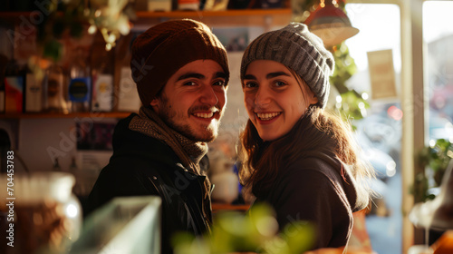 Portrait of a young couple smiling in a cafe, looking at camera.