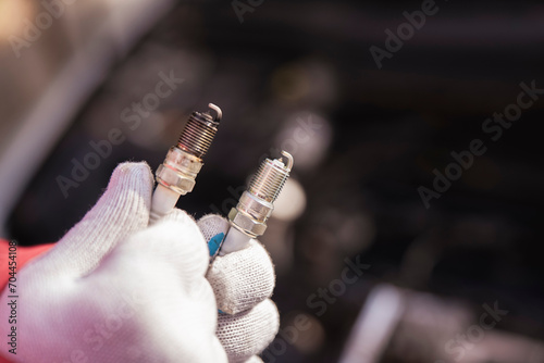 Close up mechanic hold a new and old spark plug. Copy space banner for car service