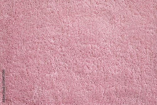 Background surface of a pink, soft, terry, textured towel close-up photo