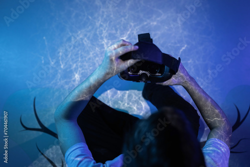 Young man wearing VR glasses sitting in a yoga pose on the virtual reality escape room floor. Fun, entertainment, and innovation concepts.