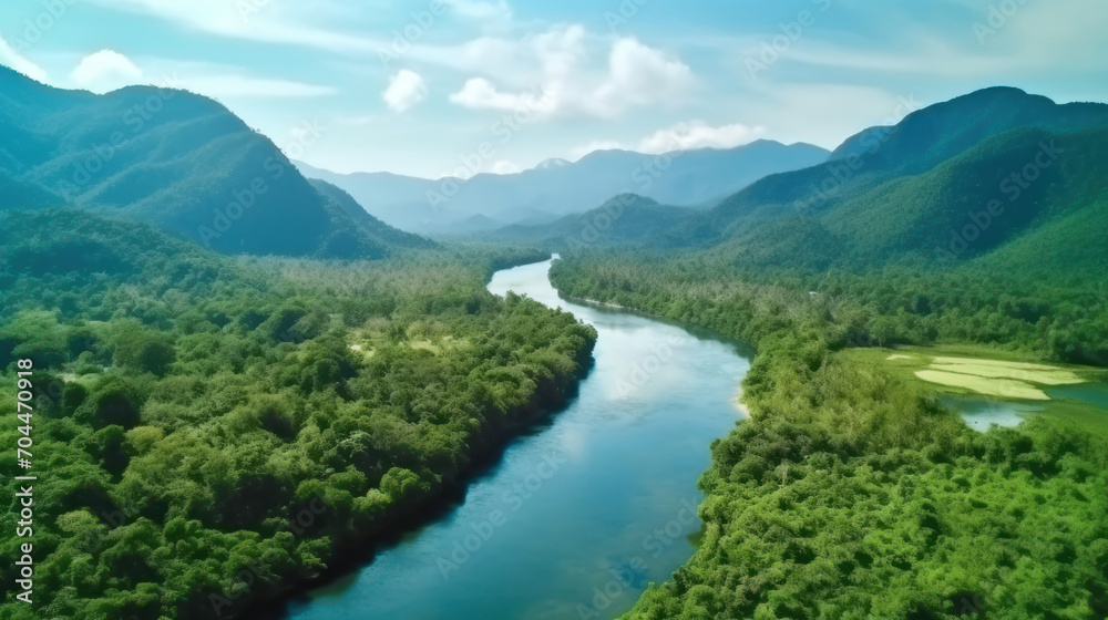 Beautiful natural scenery of river in southeast Asia tropical green forest with mountains in background, aerial view drone shot.