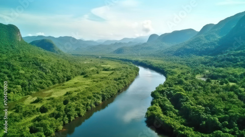Beautiful natural scenery of river in southeast Asia tropical green forest with mountains in background, aerial view drone shot.