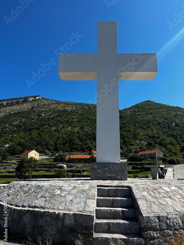 Monument to Jesus Christ and a large cross under the blue sky, above the Cievna canyon. Tourist route on the way to Grlo Sokolova photo