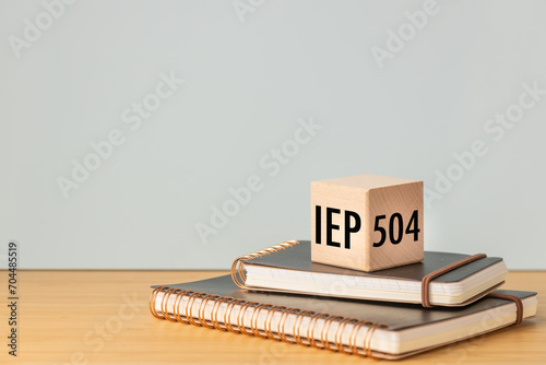 IEP Individual Education Plan Symbol. Business concept, IEP 504 program, copy space, text on a natural wooden block placed on school notebooks