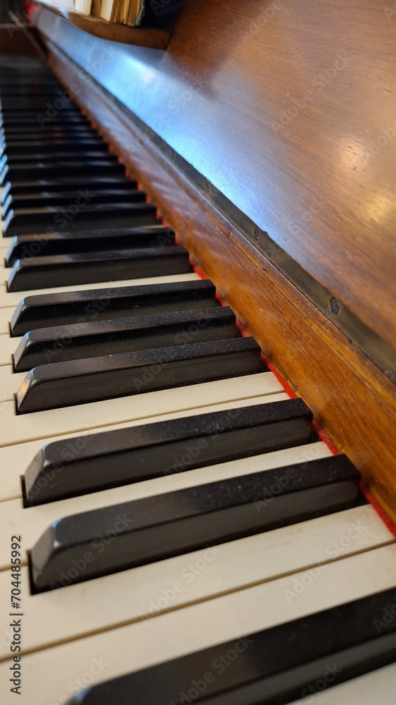 Close-up of black and white keys of an old wooden piano. Vintage piano keyboard, selective focus, Music background. 