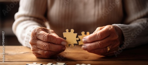 old woman's hands are putting together a puzzle photo