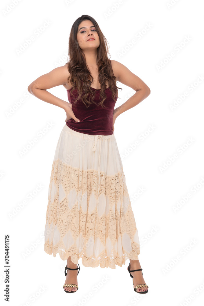 Naklejka premium Young Indian girl wearing red velvet top and creamy and lacy long skirt with elegant pose and expression