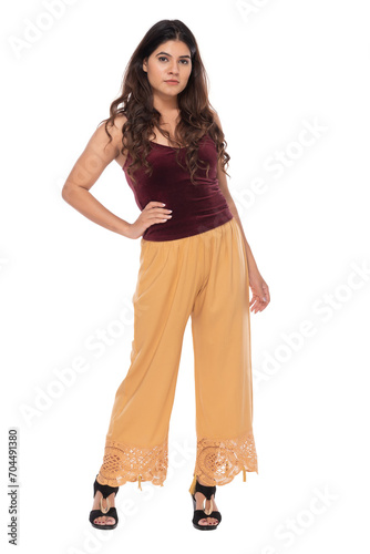 Young Indian girl wearing red velvet top and yellow lacy pants with elegant pose and expression © Kiran Joshi