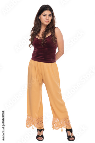 Young Indian girl wearing red velvet top and yellow lacy pants with elegant pose and expression