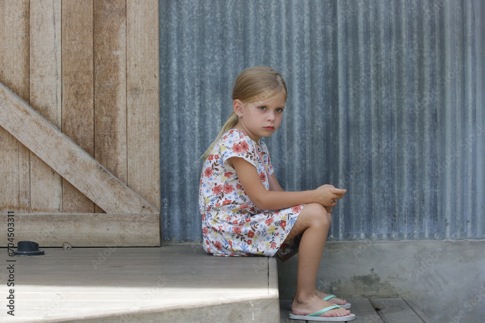 Annoyed little girl sitting on the street steps Annoyed little girl sitting on the street steps