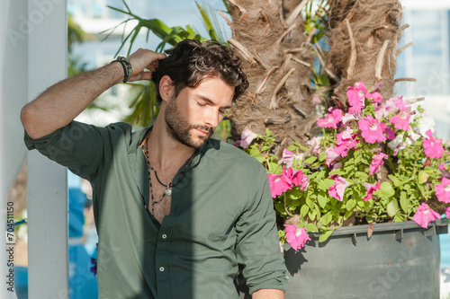 Handsome man dressed in green shirt, outdoor photo