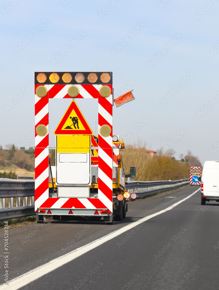 road works on the motorway without worker and the italian signs that means MEN AT WORK Reduce Speed