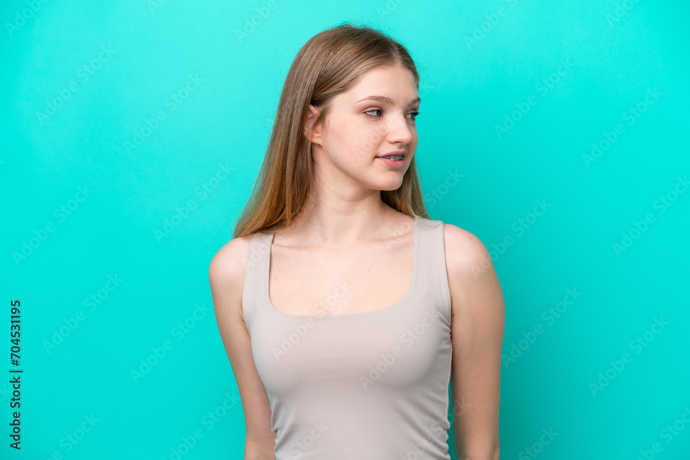Teenager Russian girl isolated on blue background looking to the side and smiling Teenager Russian girl isolated on blue background looking to the side and smiling