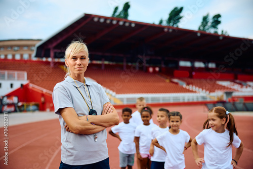 Confident coach with group of kids at athletic club. photo