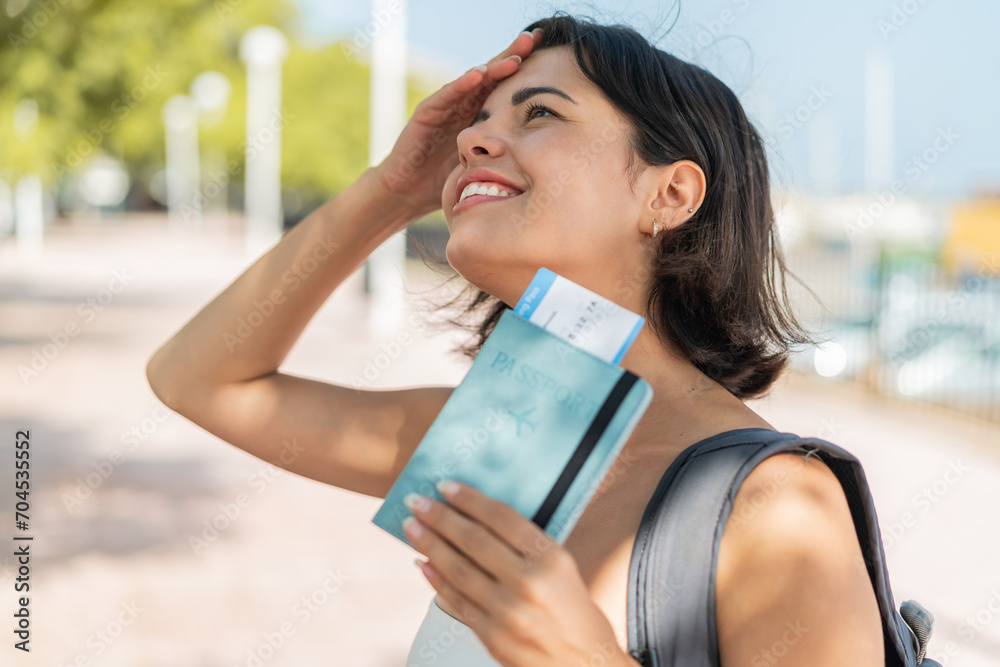 Young pretty Bulgarian woman at outdoors holding a passport with surprised expression Young pretty Bulgarian woman at outdoors holding a passport with surprised expression