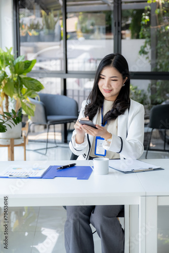 Successful businesswoman financier investors use smartphone to communicate remotely over the internet or video call to set challenging business goals and ready to achieve targets from work office