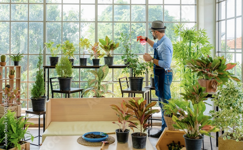 A senior man or grandfather with a mustache enjoys gardening for the tree at home after retirement
