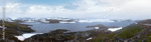 Dense fog and summer mountain landscape with lake and snow (Norway, not far Nigardsbreen glacier). Panorama.