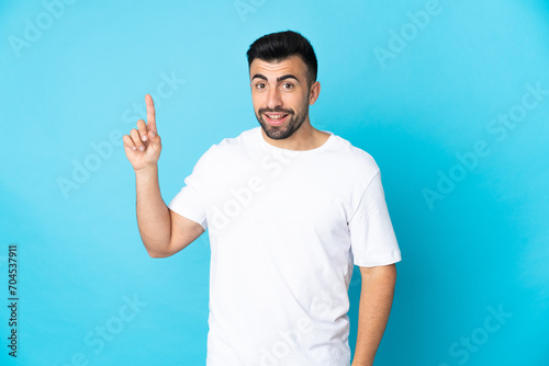Caucasian man over isolated blue background showing and lifting a finger in sign of the best