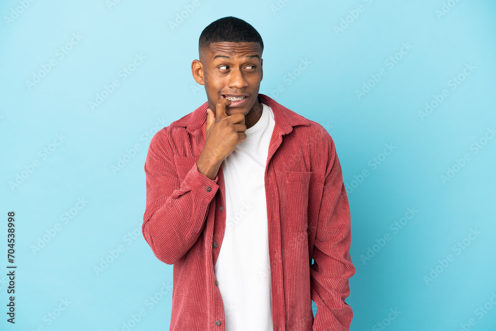 Young latin man isolated on blue background nervous and scared Young latin man isolated on blue background nervous and scared