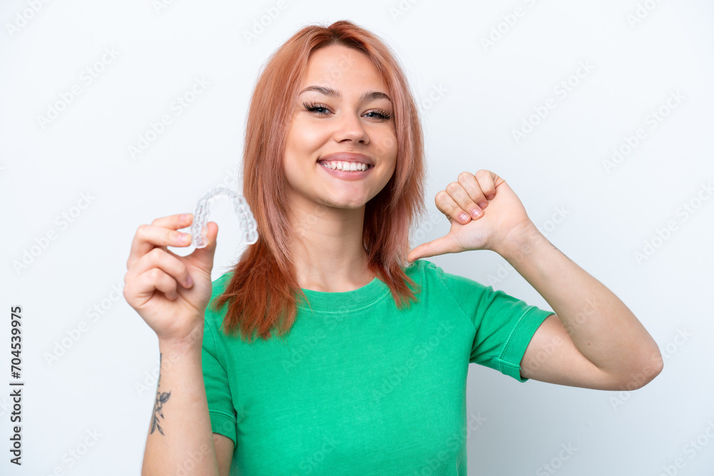 Obraz premium Young Russian girl holding invisible braces isolated on white background proud and self-satisfied