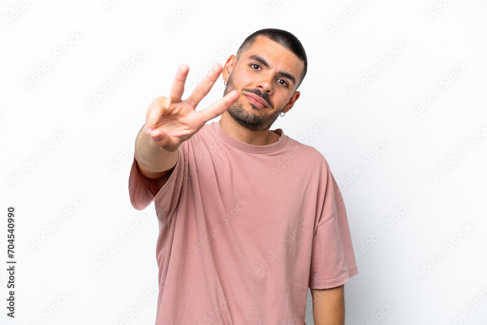 Young caucasian man isolated on white background happy and counting three with fingers Young caucasian man isolated on white background happy and counting three with fingers