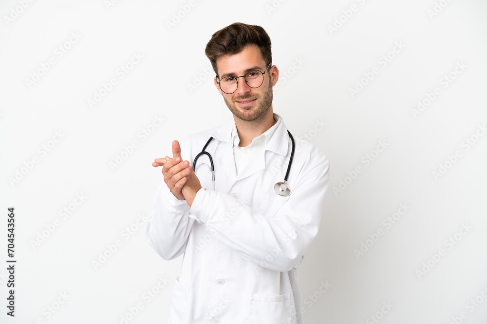 Young doctor caucasian man over isolated on white background wearing a doctor gown and applauding Young doctor caucasian man over isolated on white background wearing a doctor gown and applauding