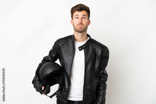 Young caucasian man with a motorcycle helmet isolated on white background and looking up