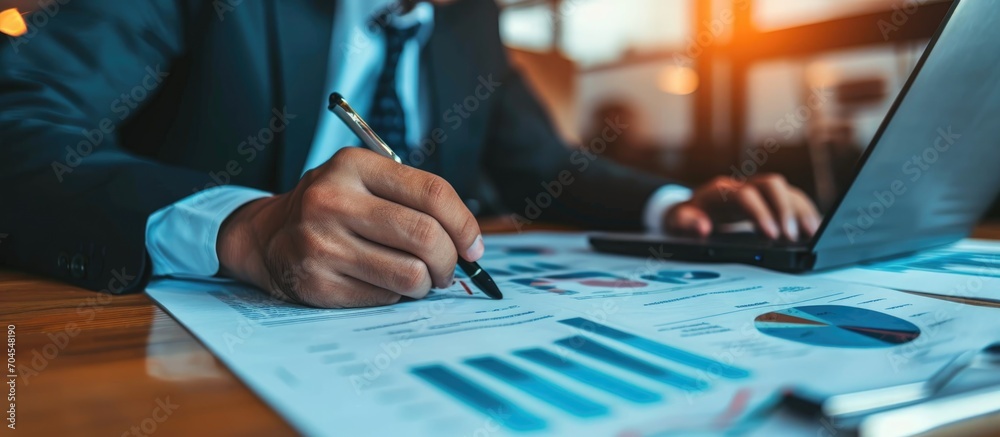 Businessman reviewing financial statement report for business's financial status. - obrazy, fototapety, plakaty 