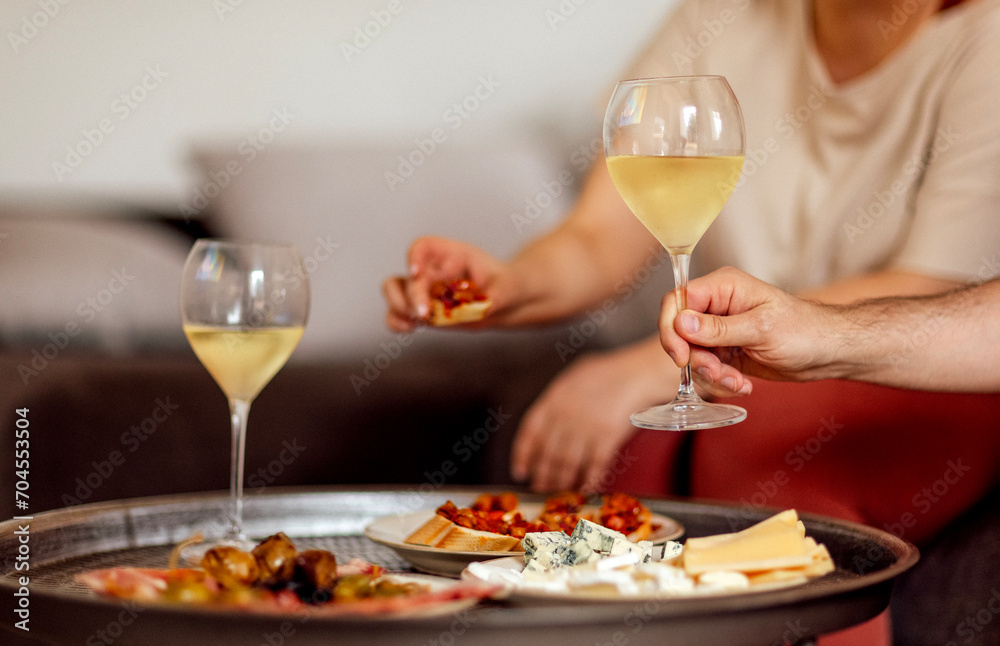Two glasses of cool champagne and plates with various snacks on a round metal coffee table Two glasses of cool champagne and plates with various snacks on a round metal coffee table