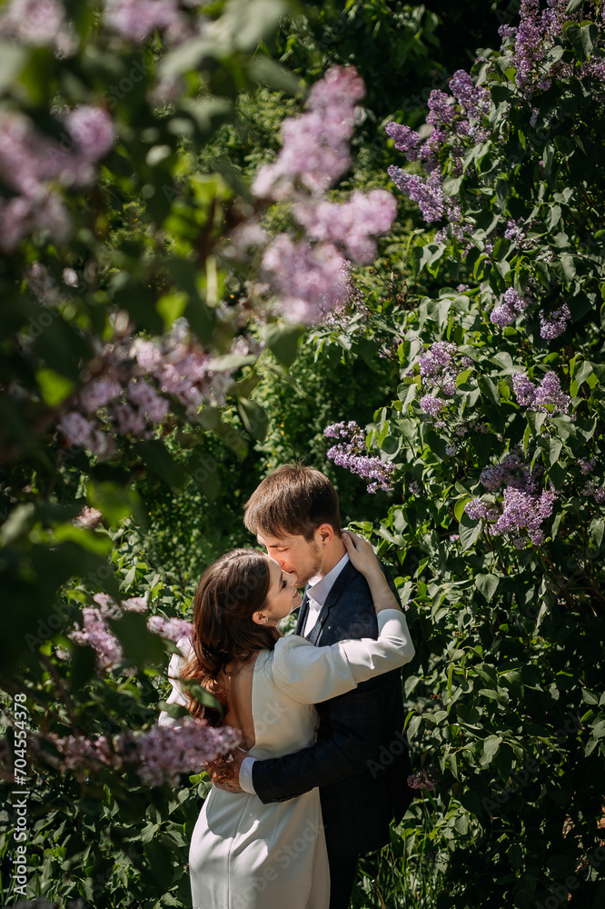 A man and a woman kissing in front of a flowering tree 5084.