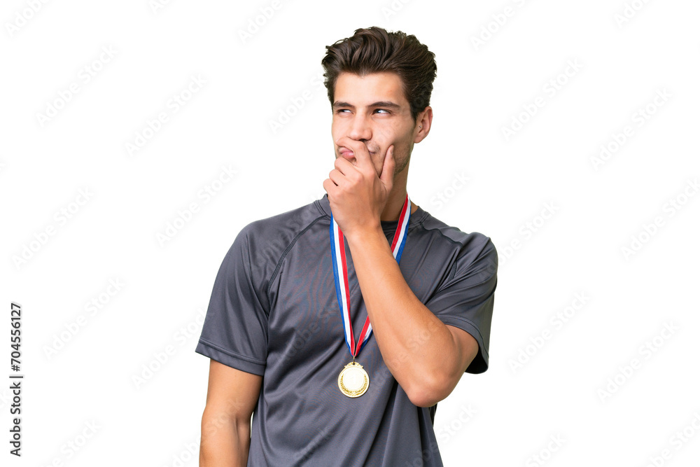 Young caucasian man with medals over isolated background having doubts and with confuse face expression