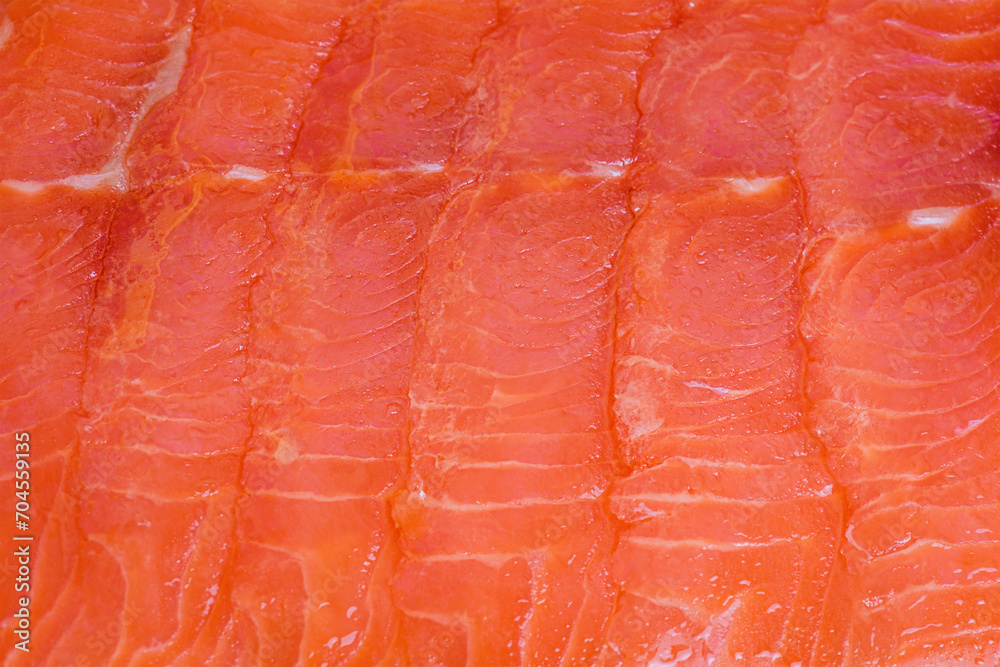 Lightly salted salmon fillet cut into thin pieces. Red fish macro photo as background. Lightly salted salmon fillet cut into thin pieces. Red fish macro photo as background.