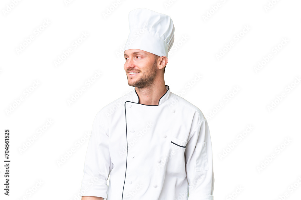 Young caucasian chef over isolated chroma key background looking side Young caucasian chef over isolated chroma key background looking side