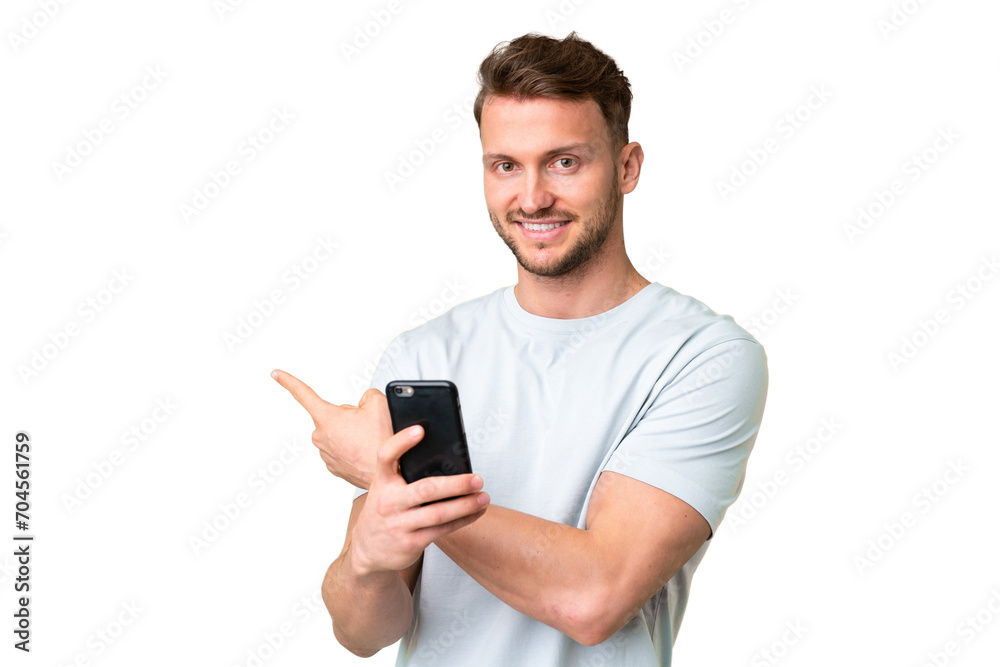 Young handsome caucasian man over isolated chroma key background using mobile phone and pointing back Young handsome caucasian man over isolated chroma key background using mobile phone and pointing back