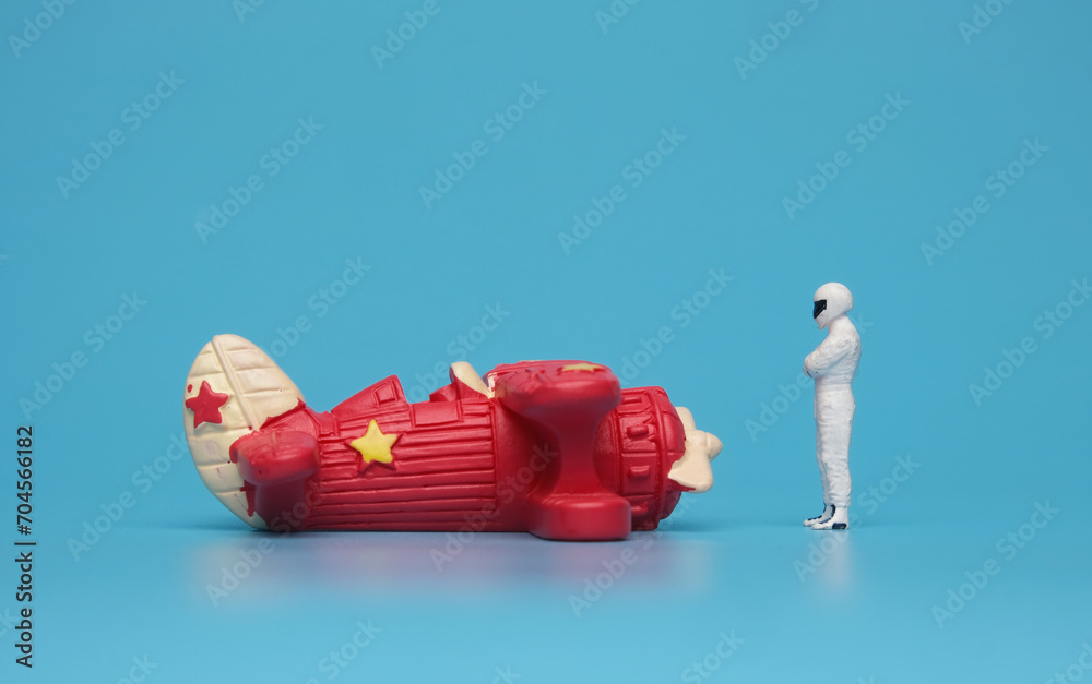 A picture of toy aircraft with racer miniature on blue background. Expert pilot. A picture of toy aircraft with racer miniature on blue background. Expert pilot.