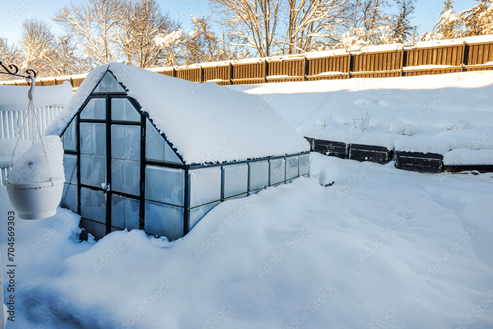 Beautiful winter view of greenhouse in garden covered with snow on frosty day. Sweden. Beautiful winter view of greenhouse in garden covered with snow on frosty day. Sweden.