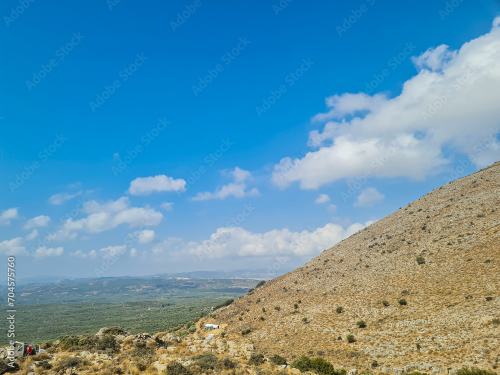 Greece island many hills with blue sky and white clouds Greece island many hills with blue sky and white clouds
