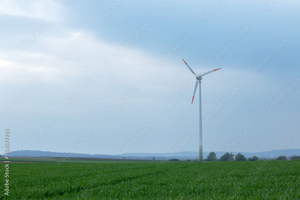 In the smoky air, a wind turbine on a grass field