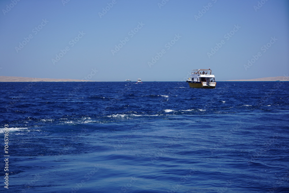 A yacht sailing in the sea. Leisure and adventure amid gentle waves and clear skies. 