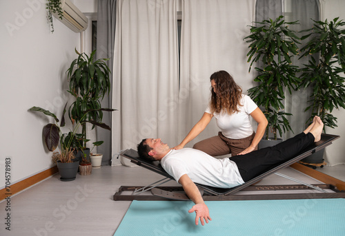 Relaxed man learning yoga poses with teacher